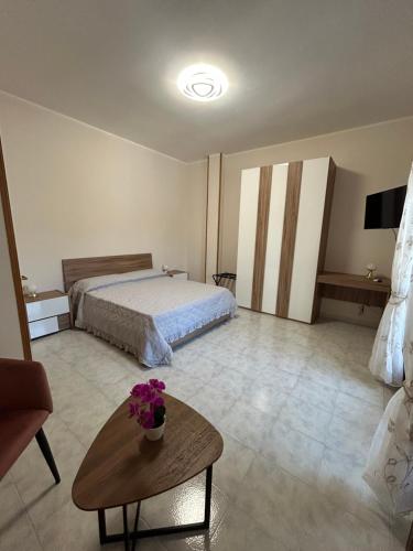 a bedroom with a bed and a table with flowers on it at Mesciu Cesare B&B in Lecce