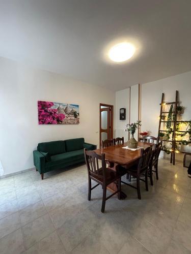 a living room with a table and a green couch at Mesciu Cesare B&B in Lecce