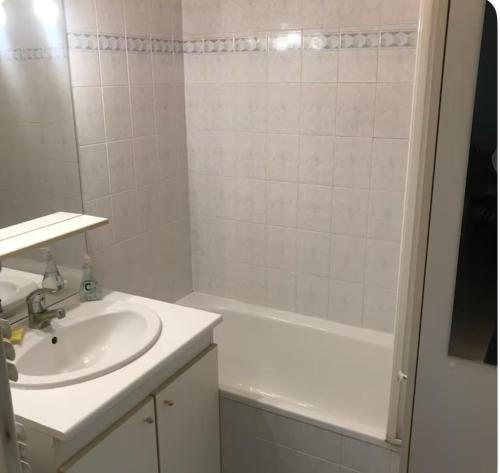 a white bathroom with a sink and a bath tub at 2 pieces Chatillon au pied du T2 - 10 minutes du metro in Châtillon