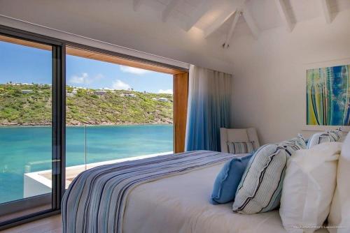 a bedroom with a bed with a view of the ocean at Luxury Villa with Ocean Views in Marigot in Marigot