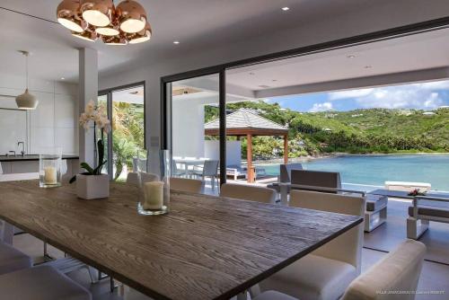 a dining room with a wooden table and a view of the ocean at Luxury Villa with Ocean Views in Marigot in Marigot