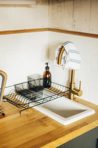 a kitchen sink with a kitchen faucet and a sinkyss at The Wildflower Shepherd's Hut in Matfen