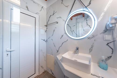 a bathroom with a sink and a mirror at Alex bar apartments in Sarakiniko