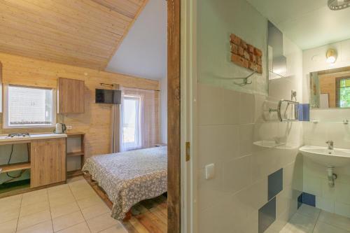 a bathroom with a bed and a sink in a room at 11 kopų in Šventoji