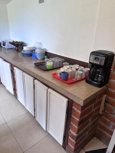 a kitchen counter with dishes and a coffee maker at W i M, Hostel & Camping in Chaupi