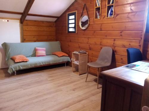 a living room with a couch and a chair at Le Palmi Chalet charmant in La Plaine des Palmistes