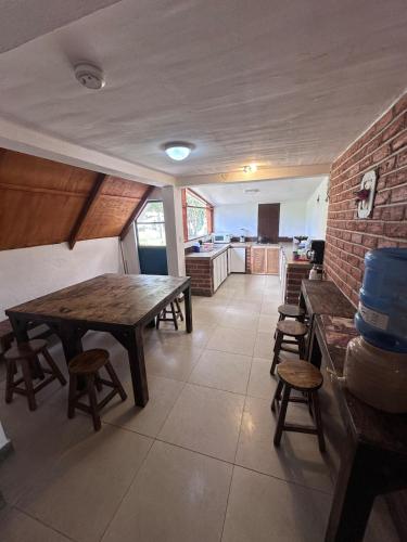a kitchen with a table and stools in a room at W i M, Hostel & Camping in Chaupi