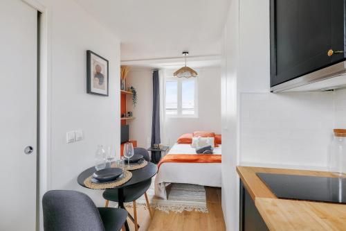 a small room with a bed and a small table at Studio cosy proche Paris et du Bois de Vincennes in Charenton-le-Pont