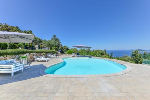 a swimming pool with chairs and an umbrella at Villa Alessia in Marciana Marina