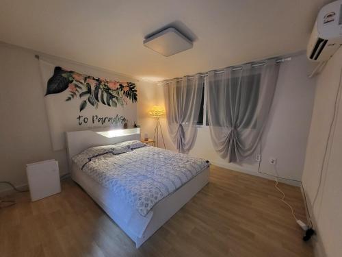a bedroom with a white bed and a window at Renovated two rooms with natural light - Guwoldong in Incheon