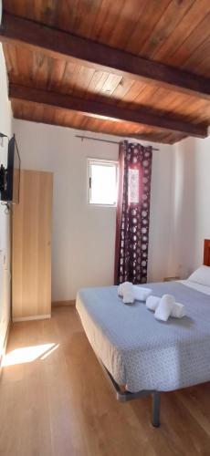 a bedroom with a bed with two towels on it at sunset lodge in Las Manchas