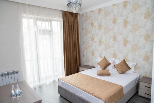 a bedroom with a large bed and a chandelier at Max Hotel, Tatev 