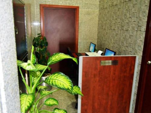 an office with a desk with a computer and a plant at Belvilla Top Stars Hotel Near Gold Souk in Abu Dhabi