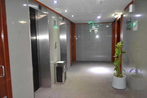 a hallway of an elevator with a plant in it at Belvilla Top Stars Hotel Near Gold Souk in Abu Dhabi