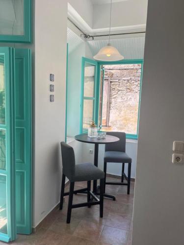 a dining room with a table and chairs and a window at My Symi Apartments in Symi