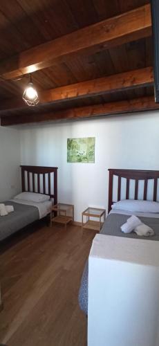 two beds in a room with wooden ceilings at sunset lodge in Las Manchas