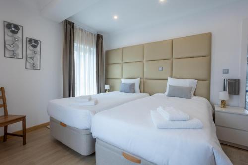 two white beds in a room with a window at Edificio Luisa Premium in Velas