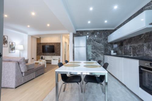 a kitchen and living room with a table and chairs at Edificio Luisa Premium in Velas