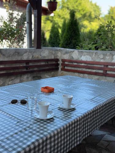 a table with two cups and glasses on top of it at Vila Dolce Vita in Kisiljevo