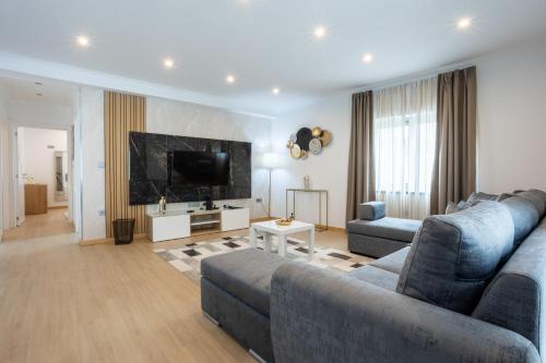 a living room with a couch and a tv at Edificio Luisa Premium in Velas