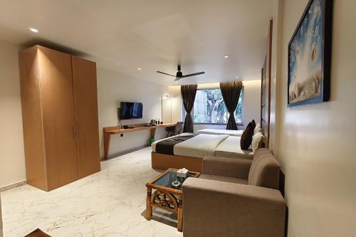 a hotel room with two beds and a couch at The Golden Arc in Pune