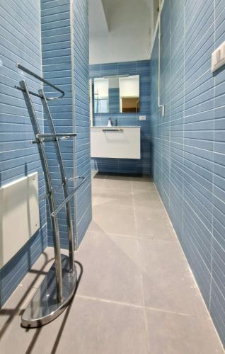 a bathroom with blue tiled walls and a tree statue at Amoenus in Atessa