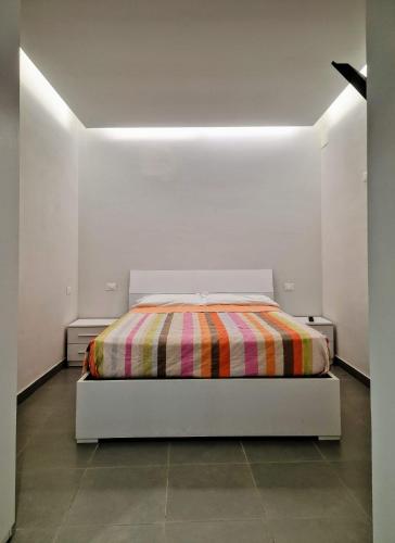 a white bedroom with a bed with a colorful blanket at Amoenus in Atessa