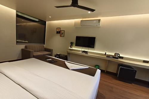a hotel room with a bed and a tv at The Golden Arc in Pune
