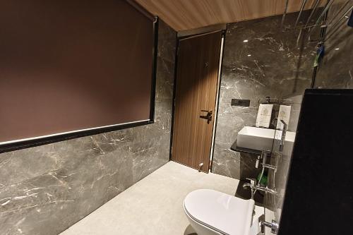 a bathroom with a toilet and a sink at The Golden Arc in Pune