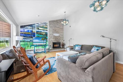 a living room with a couch and a fireplace at Unique Retreat with Private Patio, 4 King Beds and BBQ in Groton