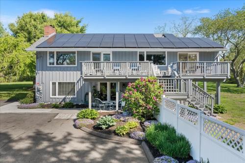 a house with a solar roof on top of it at Unique Retreat with Private Patio, 4 King Beds and BBQ in Groton