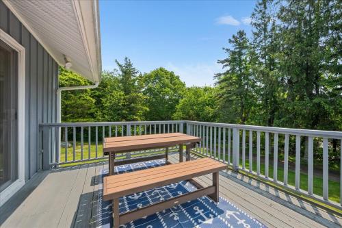 a wooden deck with a bench on a porch at Unique Retreat with Private Patio, 4 King Beds and BBQ in Groton