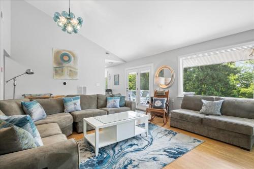 a living room with a couch and a table at Unique Retreat with Private Patio, 4 King Beds and BBQ in Groton
