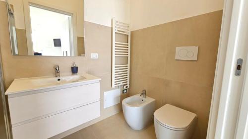 a bathroom with a sink and a toilet and a mirror at Villetta Maria in Porto Cesareo