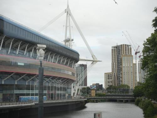 a view of a building and a river with cranes at Spacious Cardiff Apartment for Large Groups! in Cardiff
