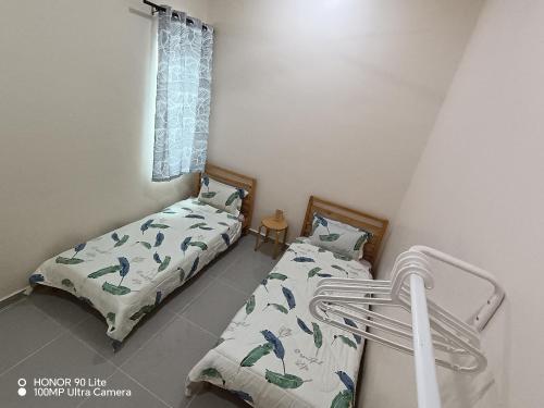 une chambre avec deux lits et une fenêtre dans l'établissement Minimalist Homestay Dungun, à Kampong Sura Tengah