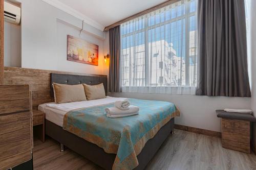 a hotel room with a bed and a window at Seven City Hotel in Antalya