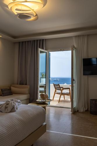 a bedroom with a bed and a view of the ocean at Νumi Boutique Hotel in Mýkonos City