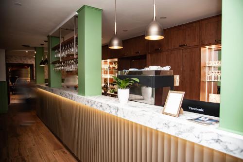 a bar in a restaurant with a plant on the counter at Penzion Fortune in Dunajská Streda