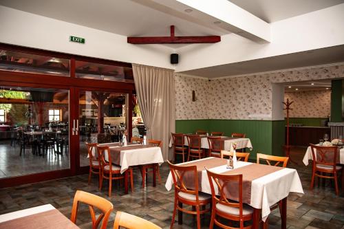 a restaurant with tables and chairs in a room at Penzion Fortune in Dunajská Streda