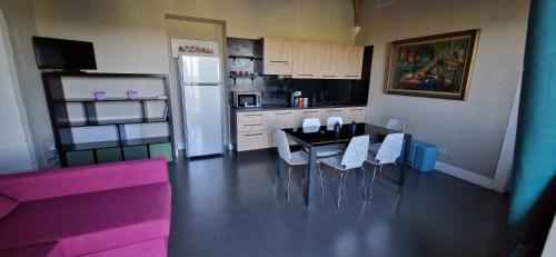 a kitchen with a table and chairs and a refrigerator at Casal de' Matti - Casa Margot in Poggibonsi