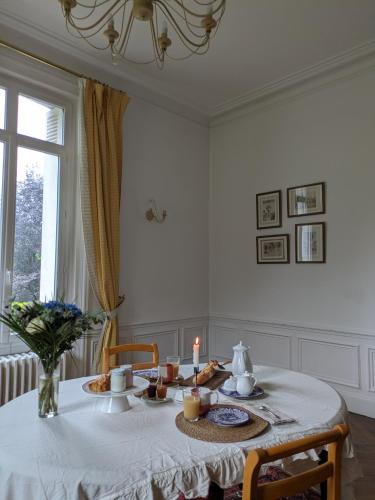 - une table à manger avec une bougie et de la nourriture dans l'établissement Chambre d'hôte - petit château à la campagne, à Saint-Aubin-Epinay