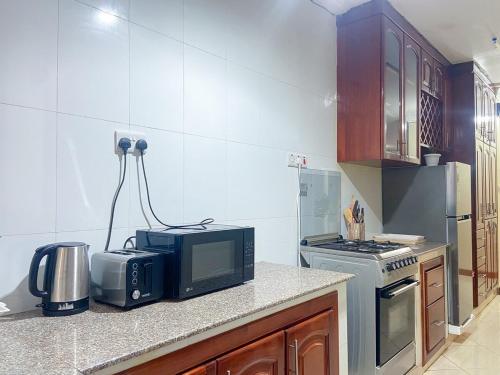 a kitchen with a microwave oven and a stove at Cozy flat in Bukoto Fast Wi-Fi in Kampala