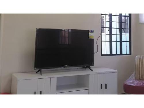 a flat screen tv sitting on top of a white cabinet at Peaceful Haven in Hermosa, Philippines - Entire House for Rent in Hermosa