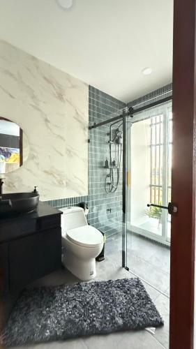 a bathroom with a toilet and a glass shower at De Flourishing Hill Pool Villa , Cha Am in Cha Am