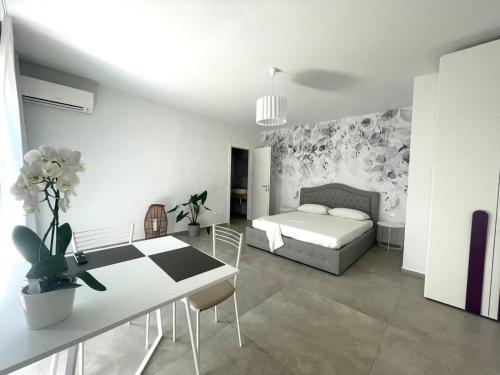 a bedroom with a bed and a table and a dining room at Villa Nina in Lagosanto