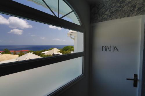 a window in a room with a view of the ocean at L'Hacienda in Saint-Pierre