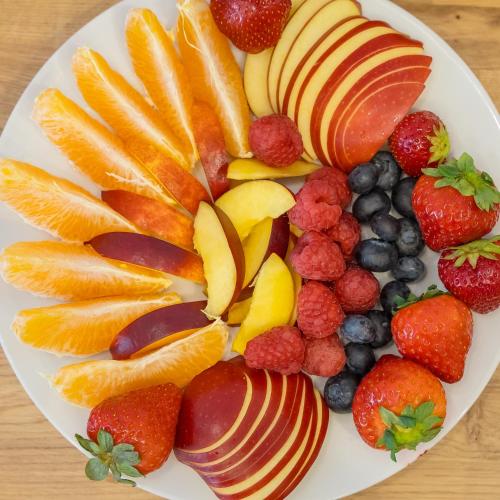a plate of fruit with oranges oranges apples and berries at Vlaštovčí dům in Nové Město nad Metují