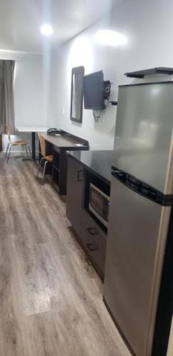 a kitchen with a refrigerator and a desk in it at Studio 6 Suites Hesperia, CA West Main Street I 15 in Hesperia