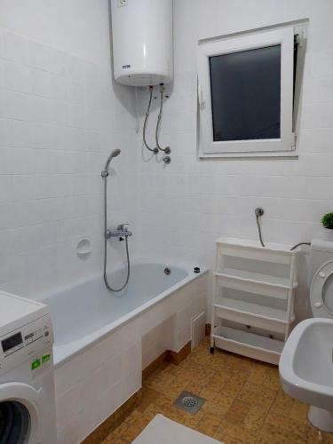 a bathroom with a tub and a toilet and a sink at Cherry 2 in Ljubuški